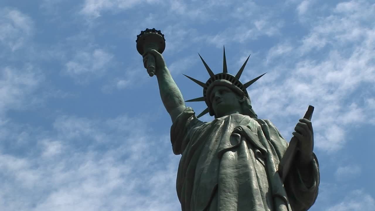 La Statua della Libertà si erge fieramente, in silhouette contro un cielo blu.
