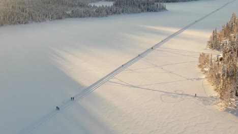 挪威的一座冰凍湖和越野滑雪者,背景是金色的日落