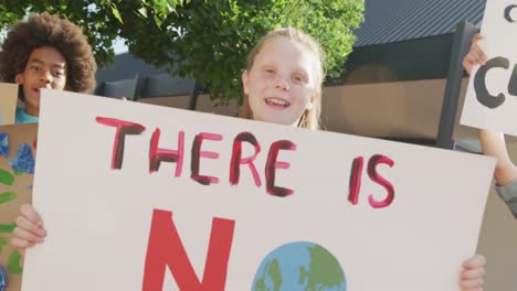 Video-Von-Verschiedenen-Schulkindern,-Die-Protestplakate-Halten-Und-Im-Freien-Singen,-Kopierraum