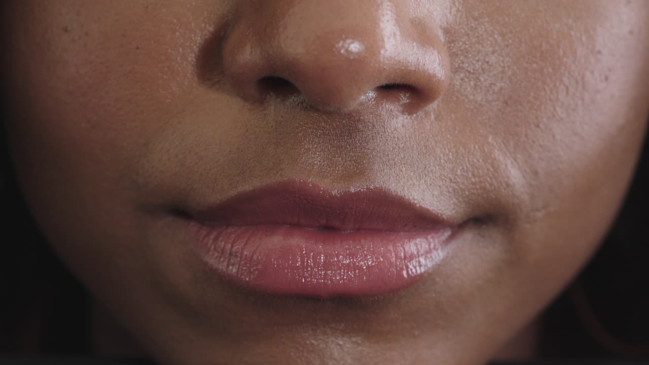 primer plano de una mujer afroamericana labios brillantes sonriendo feliz mostrando dientes sanos hermosa piel perfecta