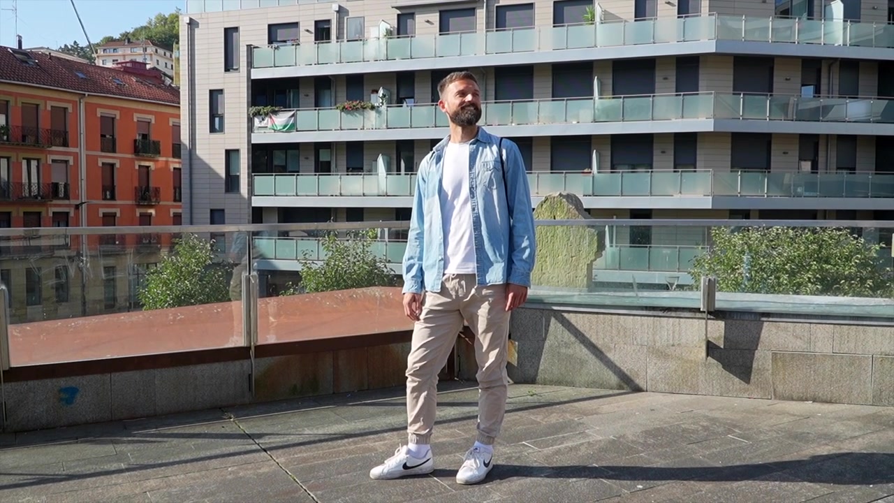 Giovane uomo che cammina su una terrazza panoramica urbana