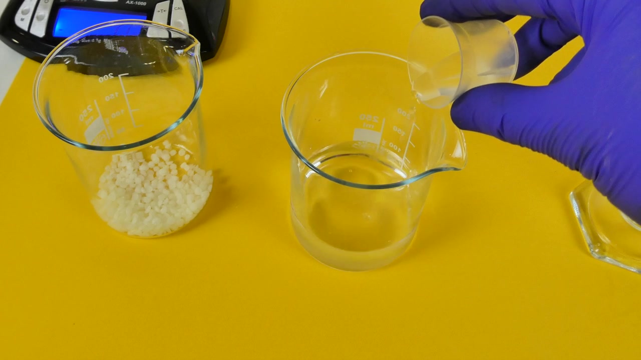 Técnico de laboratório despejando um ingrediente e mexendo uma mistura em um béquer para preparar uma emulsão cosmética.