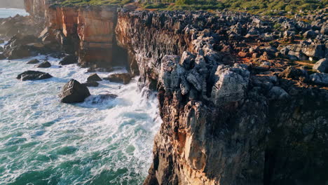 high rough coastal rock over powerful sea at sunny day. drone volcanic cliffs