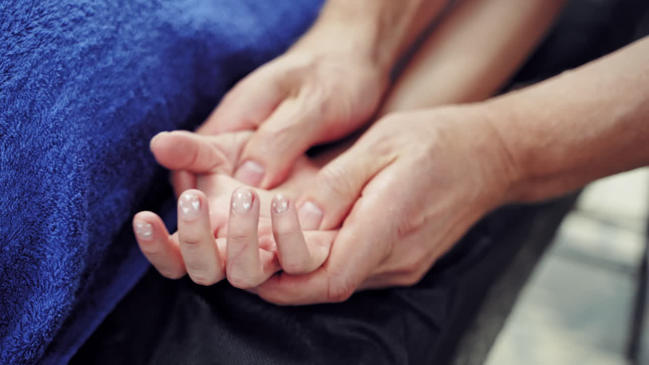 Hand massage in spa salon. Close up of kinesiologist applying pressure on hand of female patient