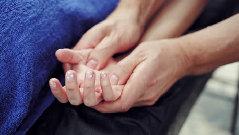 hand massage in spa salon. close up of kinesiologist applying pressure on hand of female patient