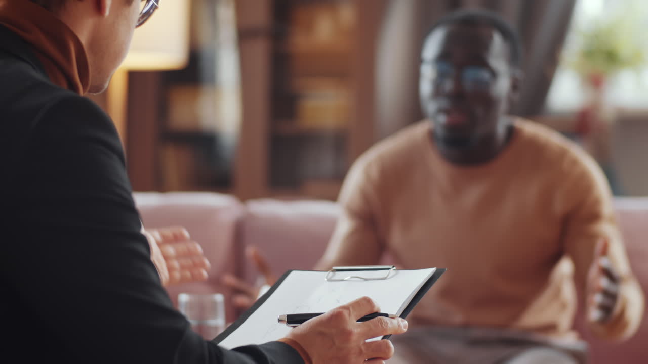 psicólogo tomando notas durante la sesión de terapia