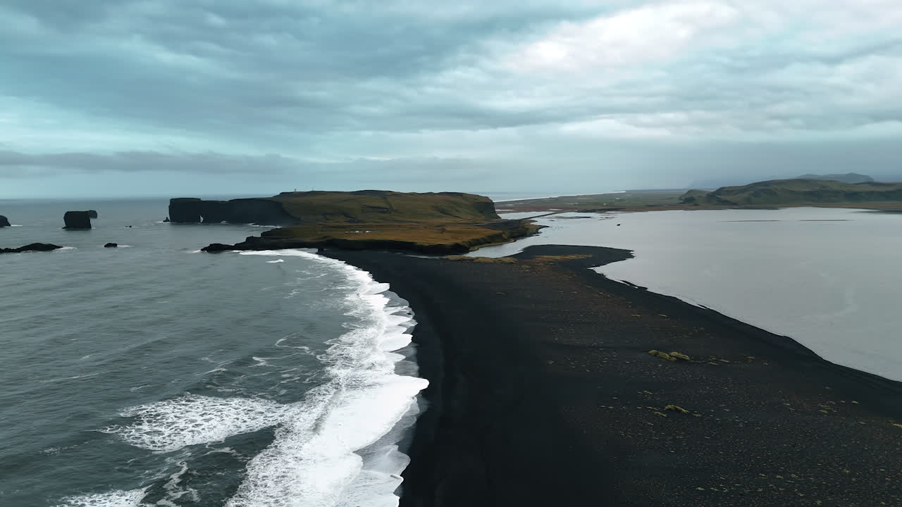 Narrow line of black beach with volcanic sand. Nordic severe scenery of Iceland from aerial view.