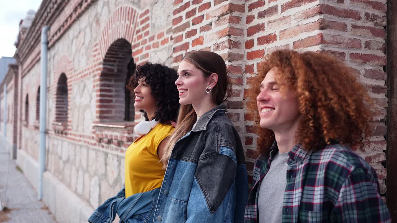 Gruppo di amici che si divertono vicino a un muro di mattoni
