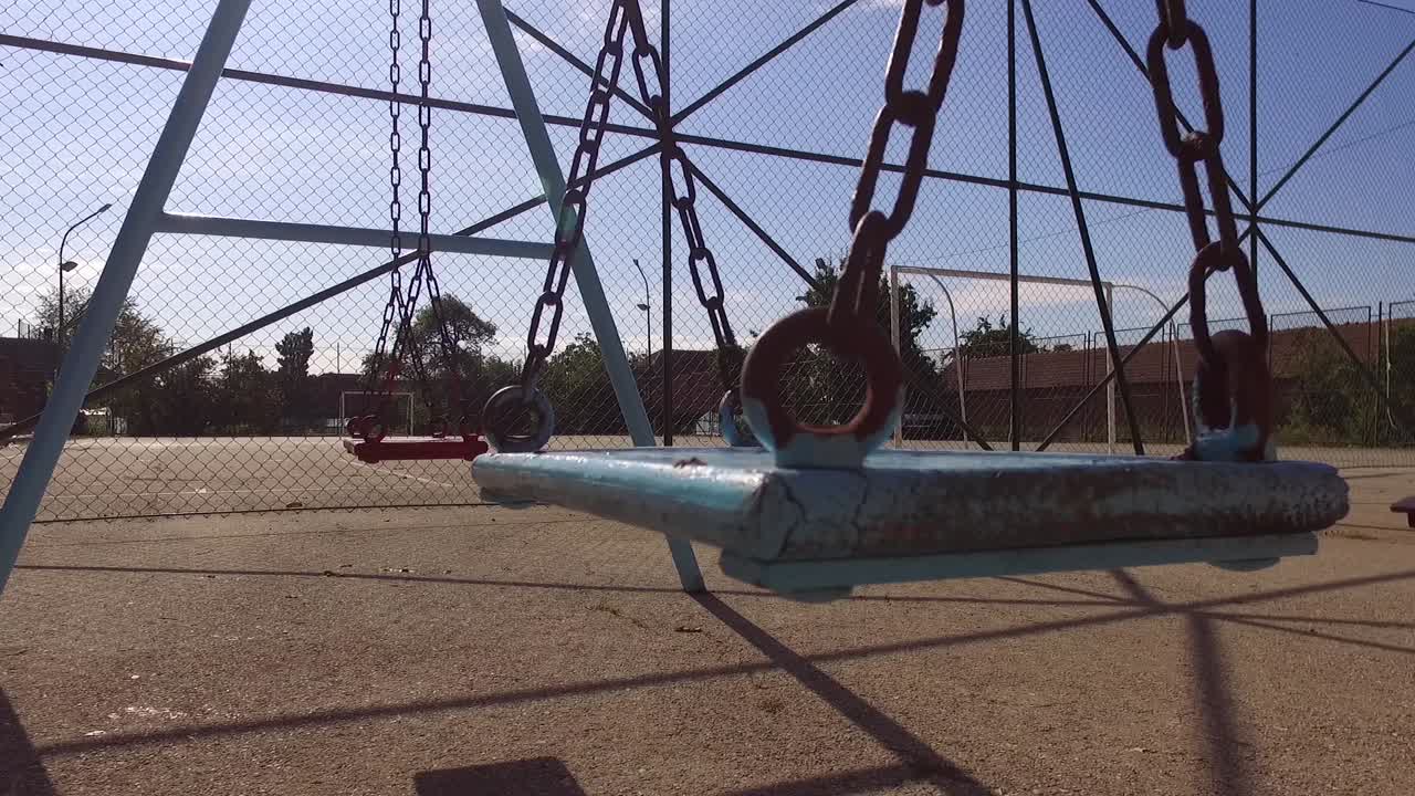 dos columpios vacíos para niños en el verano