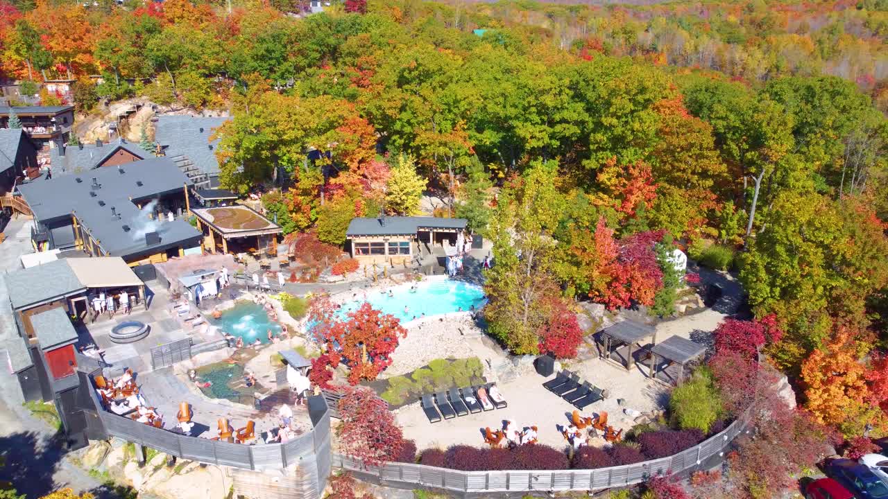 Beautiful resort with pool and autumn forest in Canada, aerial drone orbit view