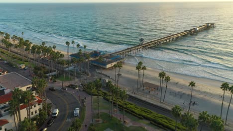 aerial spin over avenida victoria street of the pier in san clemente at sunset