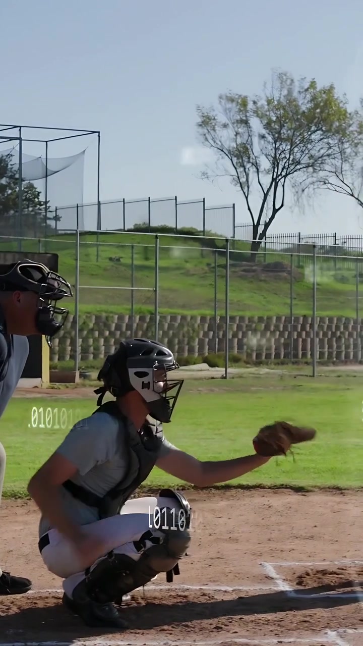 Video verticale: Lancio di baseball in arrivo, ricevitore che prende la palla al piatto per uno strike, sovrapposizione che traccia la traiettoria.