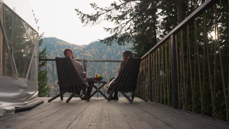 couple relaxing on deck with mountain view