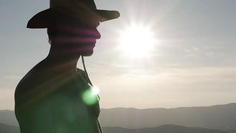 silhouette of a man looking at the distance with a hat.  natural backlight s