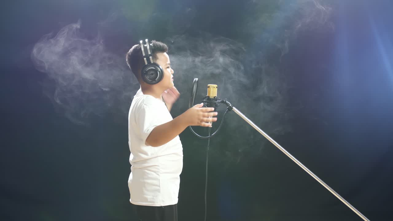 어린 소년 이 마이크 로 노래 하고 있다