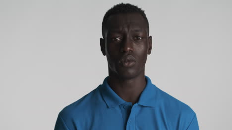 hombre afroamericano confiado en el fondo gris.