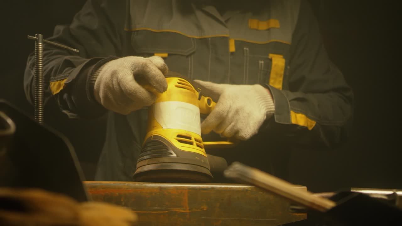 trabajador pulindo metal con un molinillo. interior de una fábrica de la industria pesada con un trabajador usando un molino. molienda eléctrica de tubos de acero en una fábrica. cámara lenta. up close. video 4k. filmado en rojo