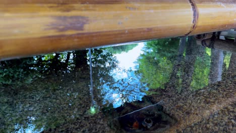 Wasser-Fließt-Sanft-Aus-Bambus-In-Einen-Ruhigen-Teich-In-Einer-Heiteren-Gartenumgebung