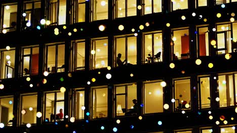 night view of a building with lit windows and people