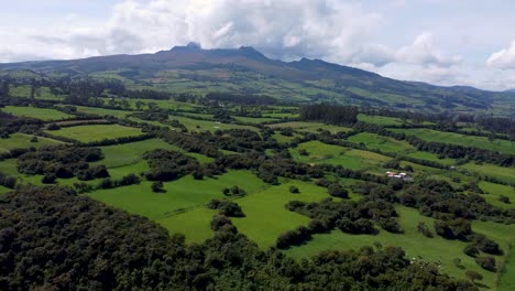 Drone-Cinematográfico-Clp-Volando-Alto-Sobre-Una-Gran-área-Cubierta-De-Verde-Y-Campos-En-Puichig,-Ecuador