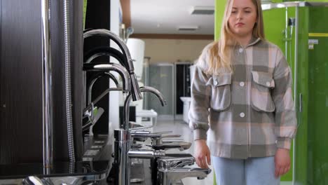 young woman shopping for faucets in a home improvement store