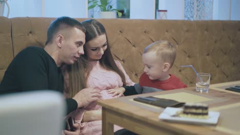 parents-talk-to-little-boy-in-pullover-in-restaurant