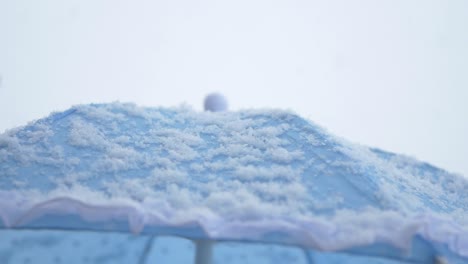 snow covered blue umbrella