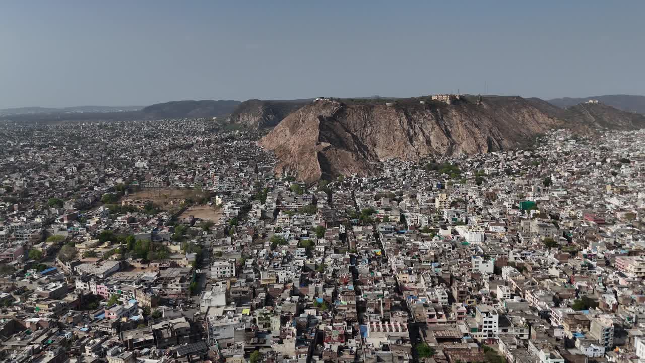 Scenic drone shot capturing the rugged terrain and fortified walls of a hilltop fortress.