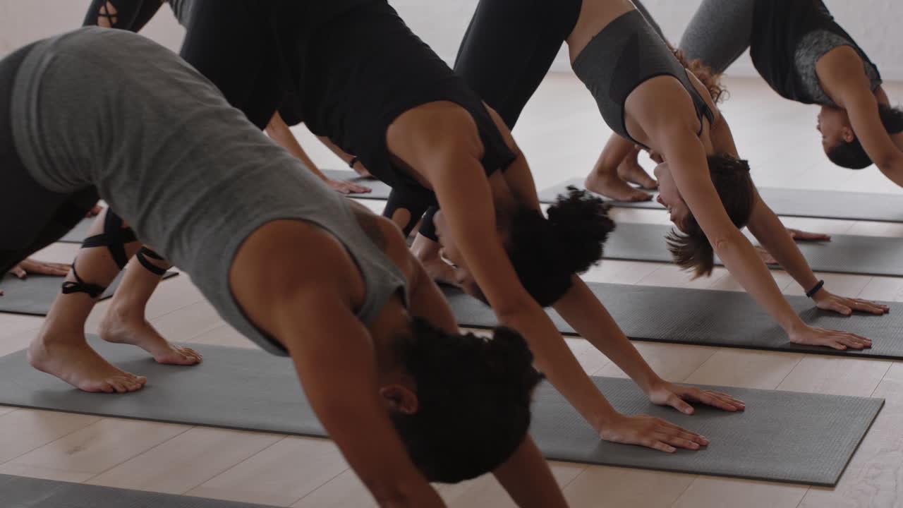 yoga class of young women practicing childs pose enjoying healthy lifestyle exercising in fitness studio