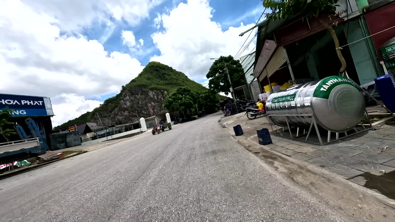 POV Drive Through a Vietnamese Street with Mountains, Scooter, and Urban Scenery