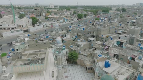 Aerial-drone-footage-of-white-stone-buildings-and-traffic-in-Lines-Area,-Karachi