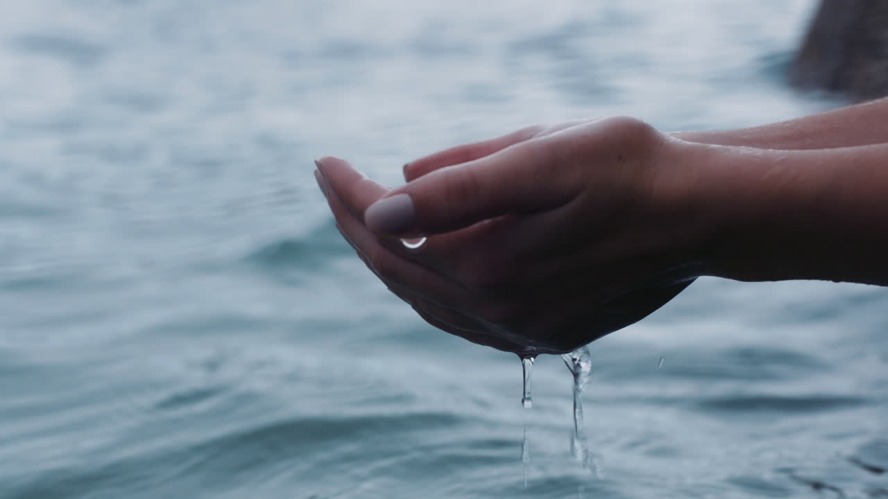 mani vicine che tengono l'acqua persona assetata che beve dal fiume fresco