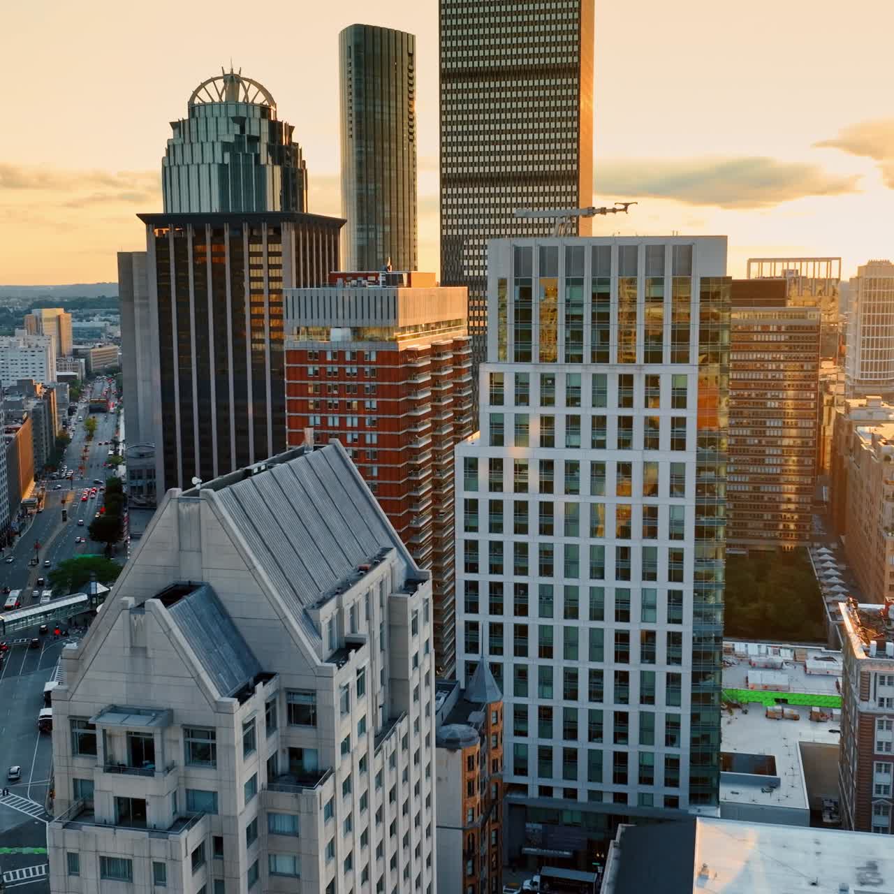 Flight among the high-rise complex of buildings in Boston downtown. Setting sun light reflects in the windows of the skyscrapers