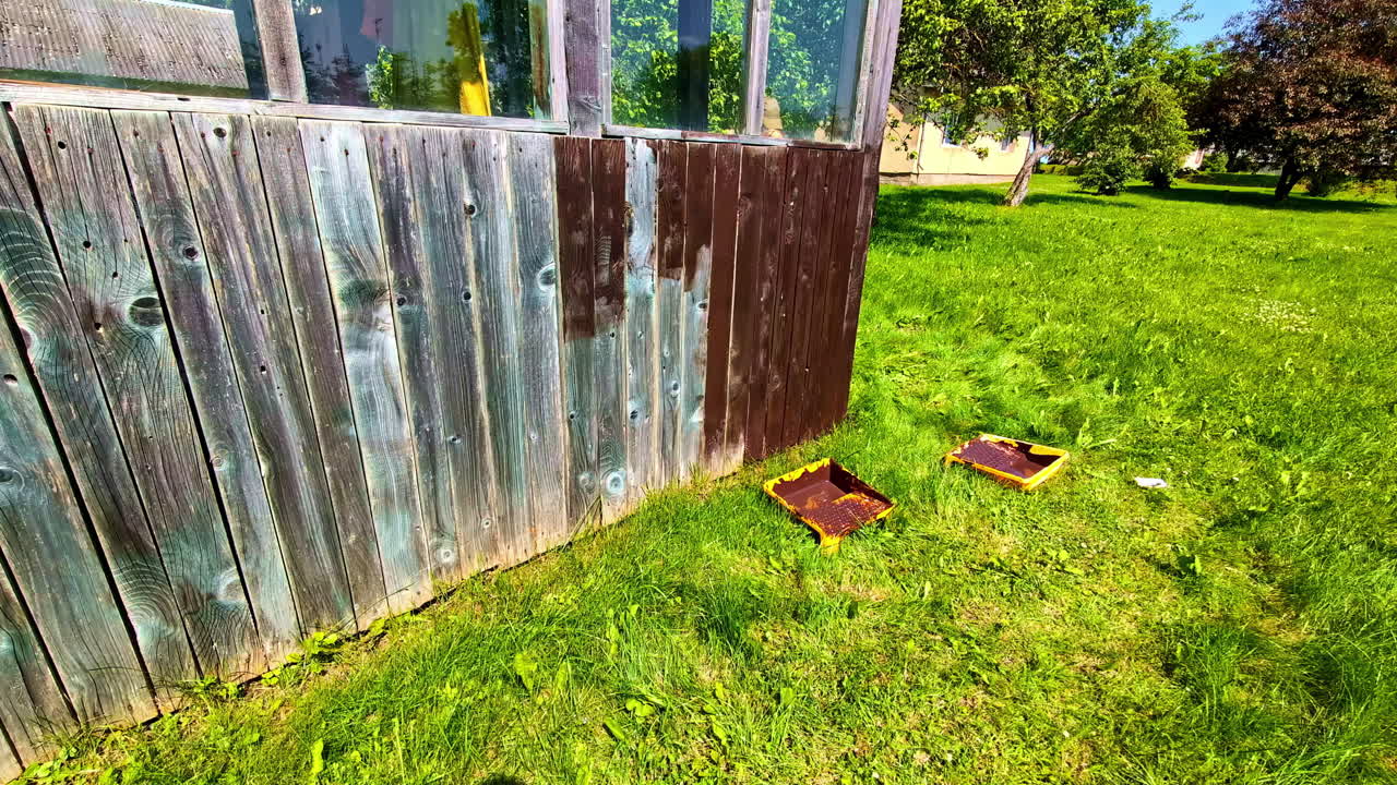 Woman Paints The Wooden Plank Walls Of House. - static shot
