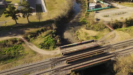 Antenne---Person,-Die-Neben-Eisenbahn-Und-Fluss-In-Maschwitz,-Argentinien,-Joggt