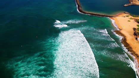 foamy ocean waves splashing on the beach in oahu island, hawaii - aerial drone shot