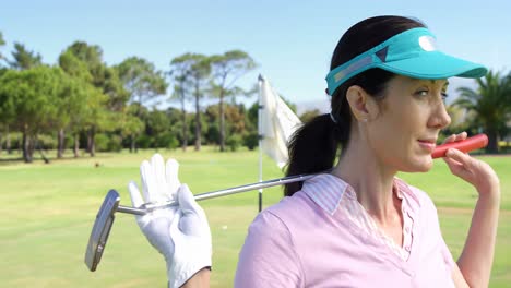 golfer carrying golf club over shoulder while standing on the golf course