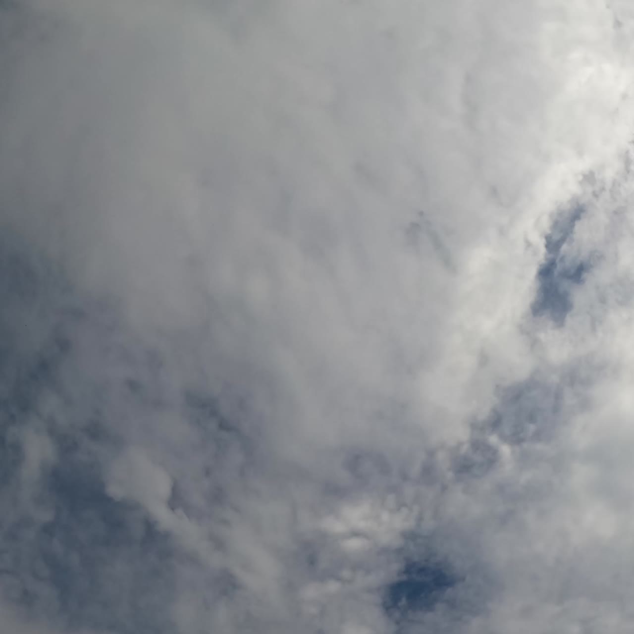 Pembentukan lanskap awan hujan di atmosfer. Awan cirrus menutupi langit biru. Sudut pandang rendah