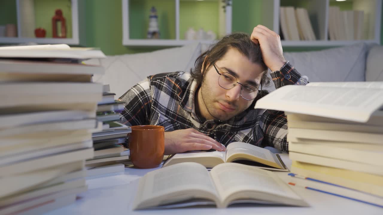 el joven cansado está cansado de mirar los libros.