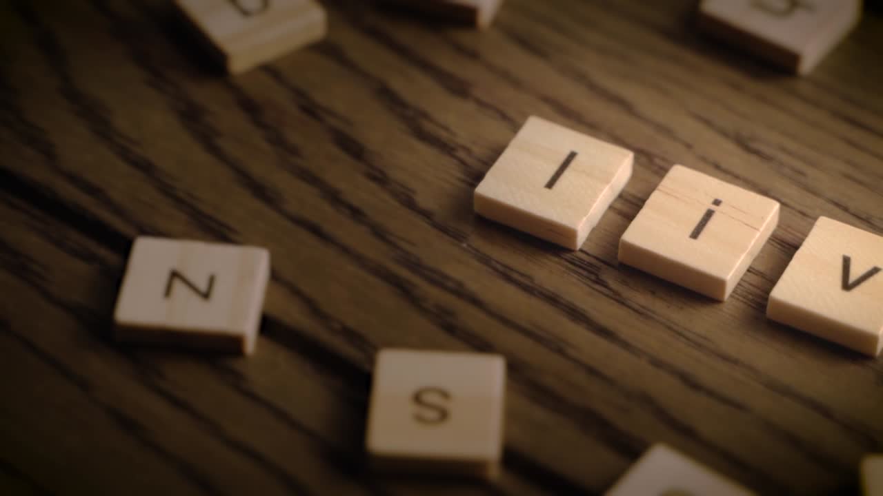 Wooden tiles spell the word live as the camera pans smoothly across a warm-toned wooden surface.