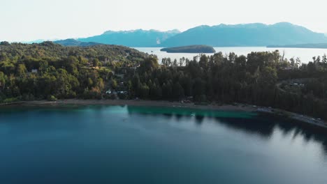 emerald colored lake with a beach, people and a paddle canoe