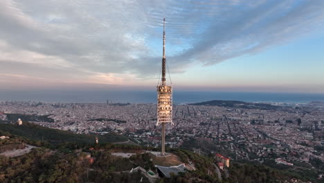 torre de antena de collserola al atardecer en el tibidabo con la ciudad de barcelona al fondo, españa