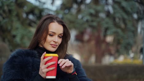 woman holding coffee cup. happy woman drinking cup of coffee in the street