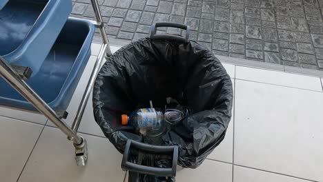 person throwing a plastic bottle into a bin