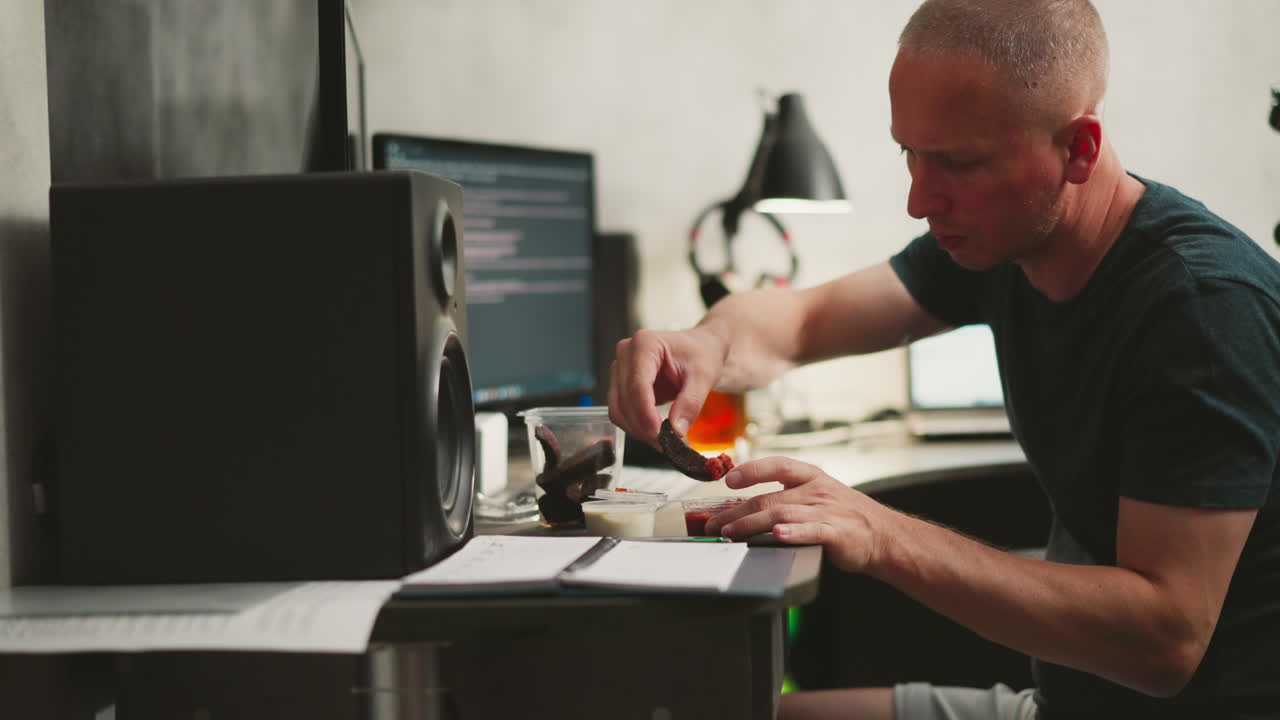 Man eating a snack at his home office desk