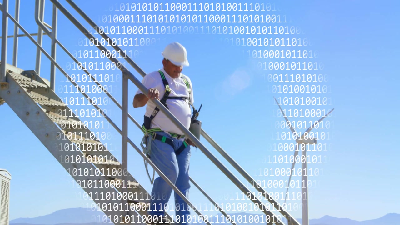 Tech checking harness then descending stairs at wind farm, binary overlay obscuring view