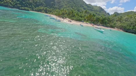 Flying-toward-idyllic-Playa-Ermitano-beach-with-tourists-in-Dominican-Republic