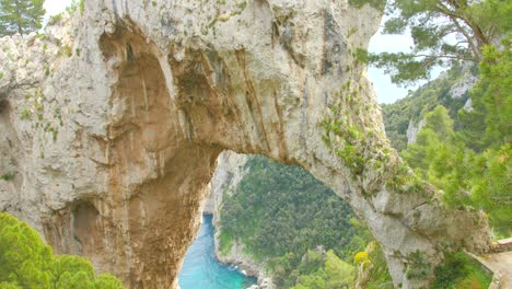 Arco-Naturale-Natural-Stone-Arch-In-Scenic-Landscape-Of-The-Mediterranean-Island-Of-Capri,-Italy---tilt-up