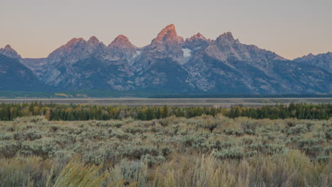 Filmischer-Schieberegler,-Zeitraffer,-Bewegung-Rechts,-Sonnenaufgang,-Rosa,-Orange,-Rote-Töne,-Warmes-Erstes-Licht,-Morgen,-Grand-Teton-Nationalpark,-Jackson-Hole,-Wyoming,-Hohes-Gras,-Spätherbst,-Herbstgelb,-Atemberaubende-Landschaft