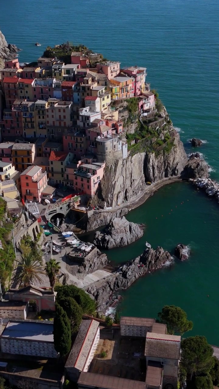Mouvement de drone vertical au-dessus du village coloré de Manarola à flanc de falaise, Cinque Terre